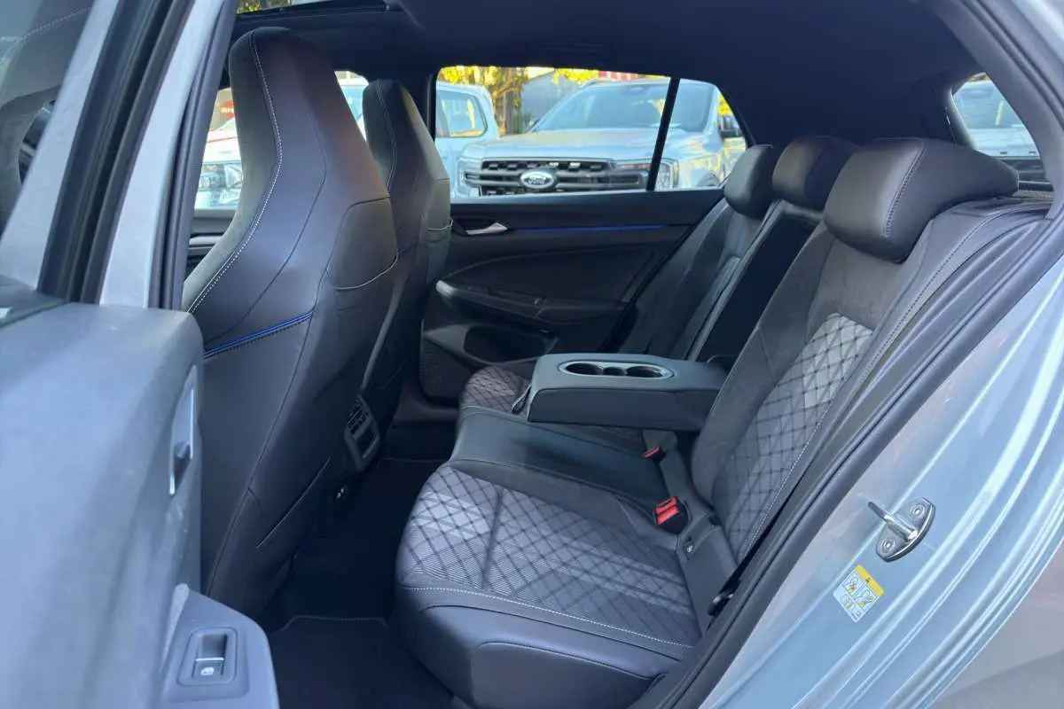 Vue intérieure côté droit de la banquette arrière en cuir noir et tissu gris de la Volkswagen Golf E-TSI 150 R-Line 2026 gris argent dolomite.