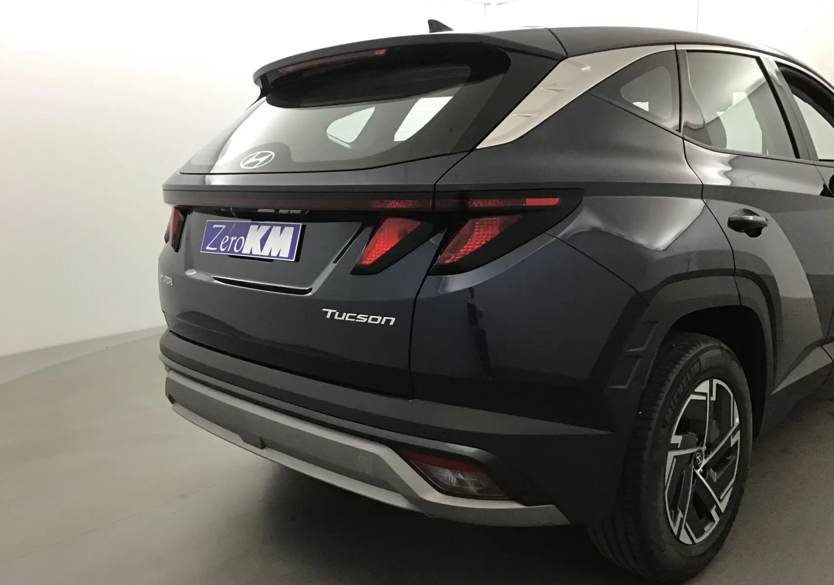 Vue 3/4 arrière droite du Hyundai Tucson 2025 bleu Salling avec feux arrière LED et jantes alliage 17 pouces.