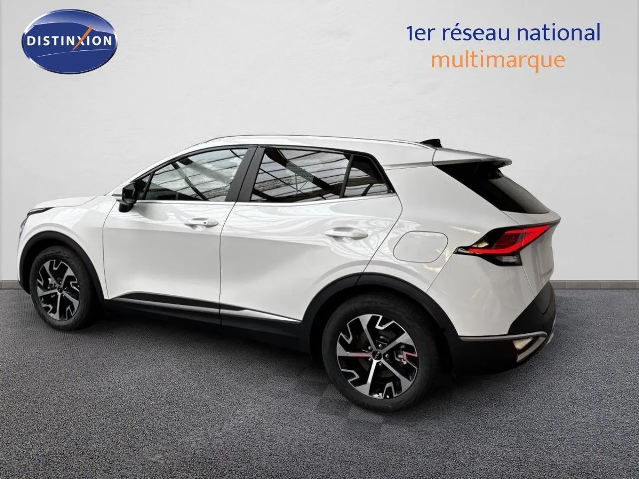 Vue de profil côté gauche d’un KIA SPORTAGE 1.6 GPL 160CH STYLE blanc nacré métal avec jantes noires et détails rouges.