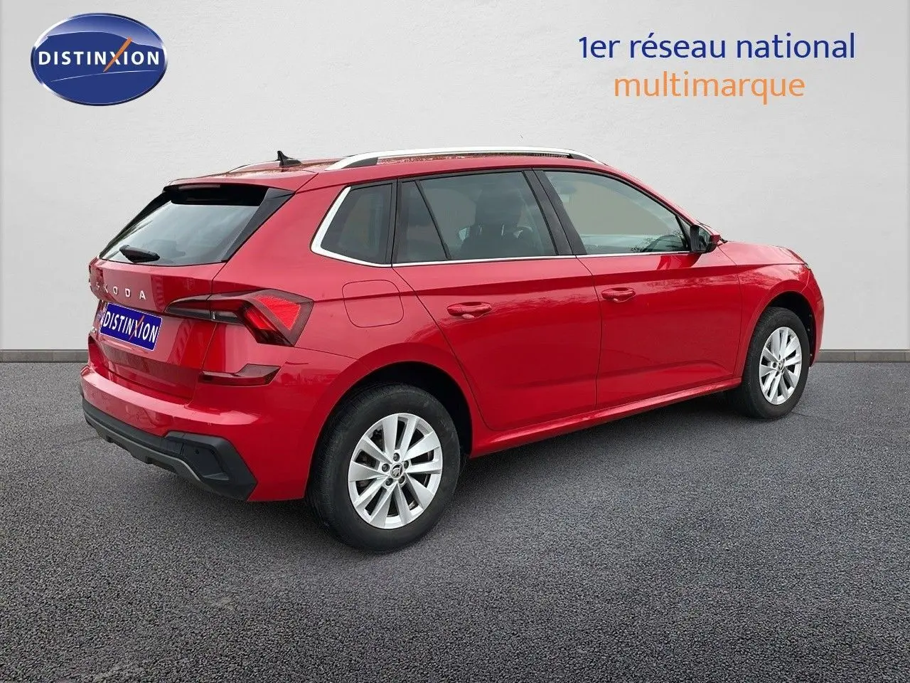 Vue 3/4 arrière droite d'un Skoda Kamiq rouge Velvet Metal 2024 avec jantes alliage et toit noir.