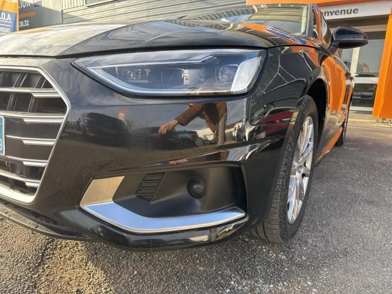Gros plan sur l'avant droit noir brillant de l'Audi A4 Avant 30 TDI avec phares LED et jante alu visible.