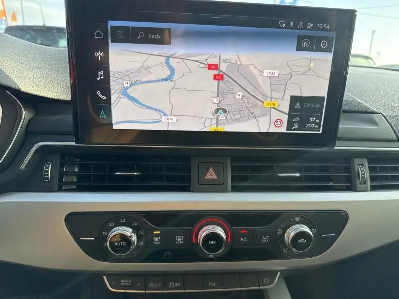 Vue rapprochée du tableau de bord noir de l'Audi A4 Avant 30 TDI 2022, avec écran GPS et commandes climatisation.