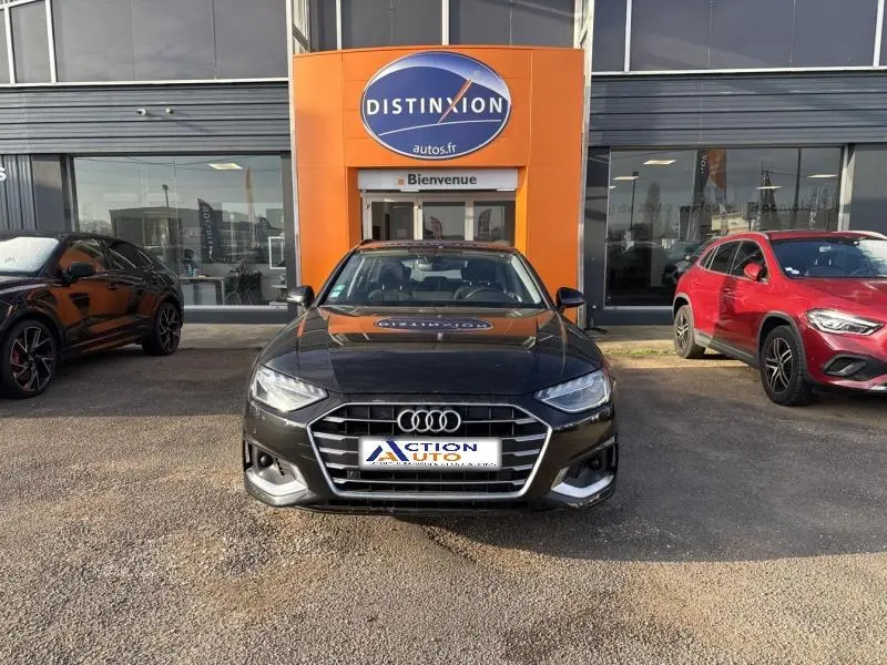 Audi A4 Avant 30 TDI noire vue de face, avec calandre chromée et phares LED, stationnée devant un garage Distinxion.