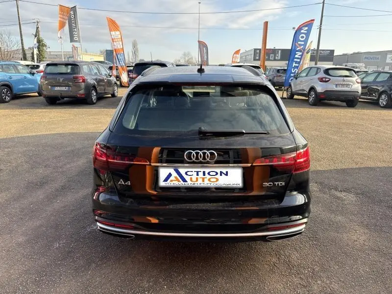 Vue arrière d'une Audi A4 Avant 30 TDI noire brillante, avec feux arrière LED et double sortie d'échappement chromée.