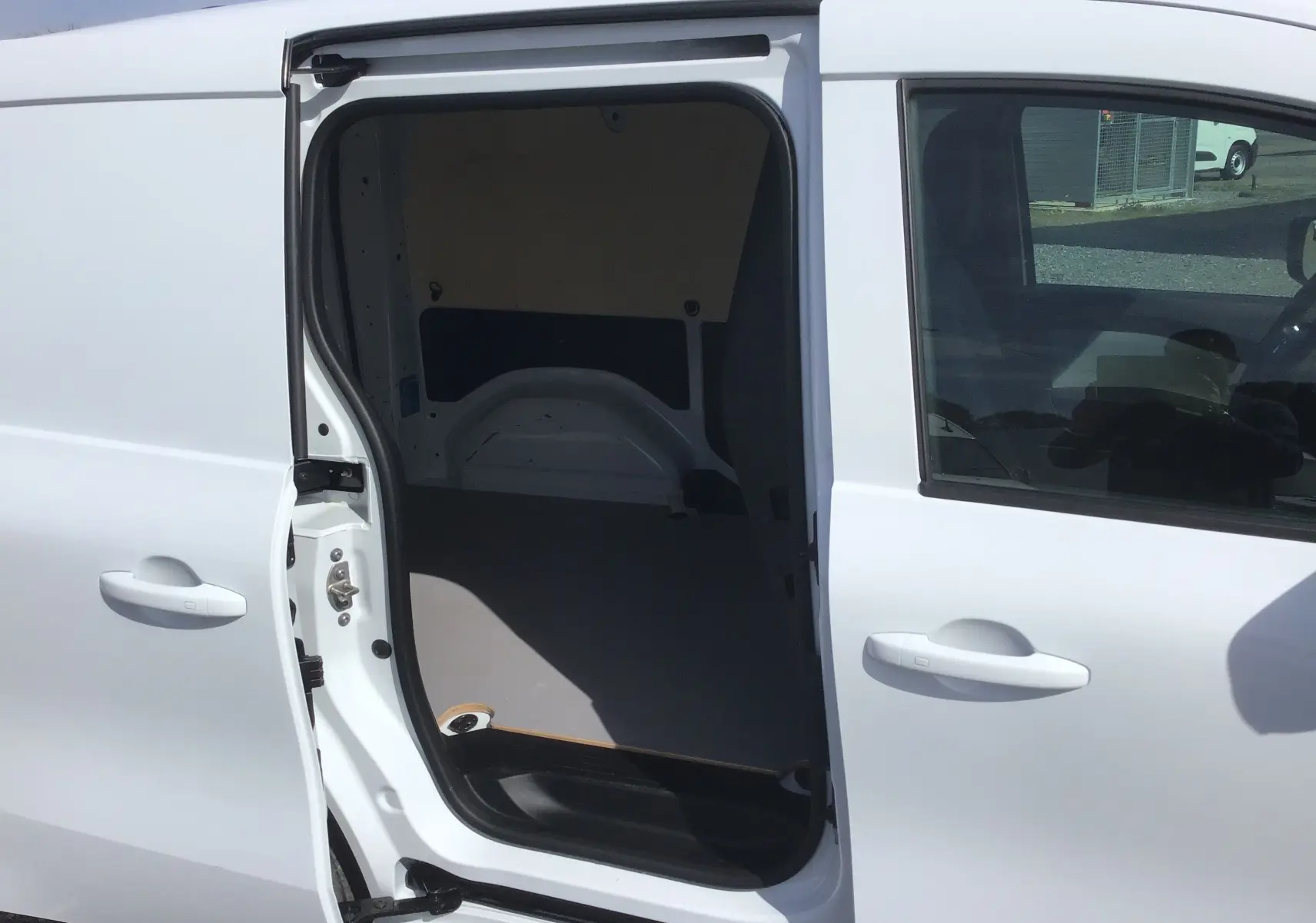 Vue latérale gauche sur le Renault Kangoo Van blanc 2024 avec porte coulissante ouverte montrant l’espace de chargement vide.