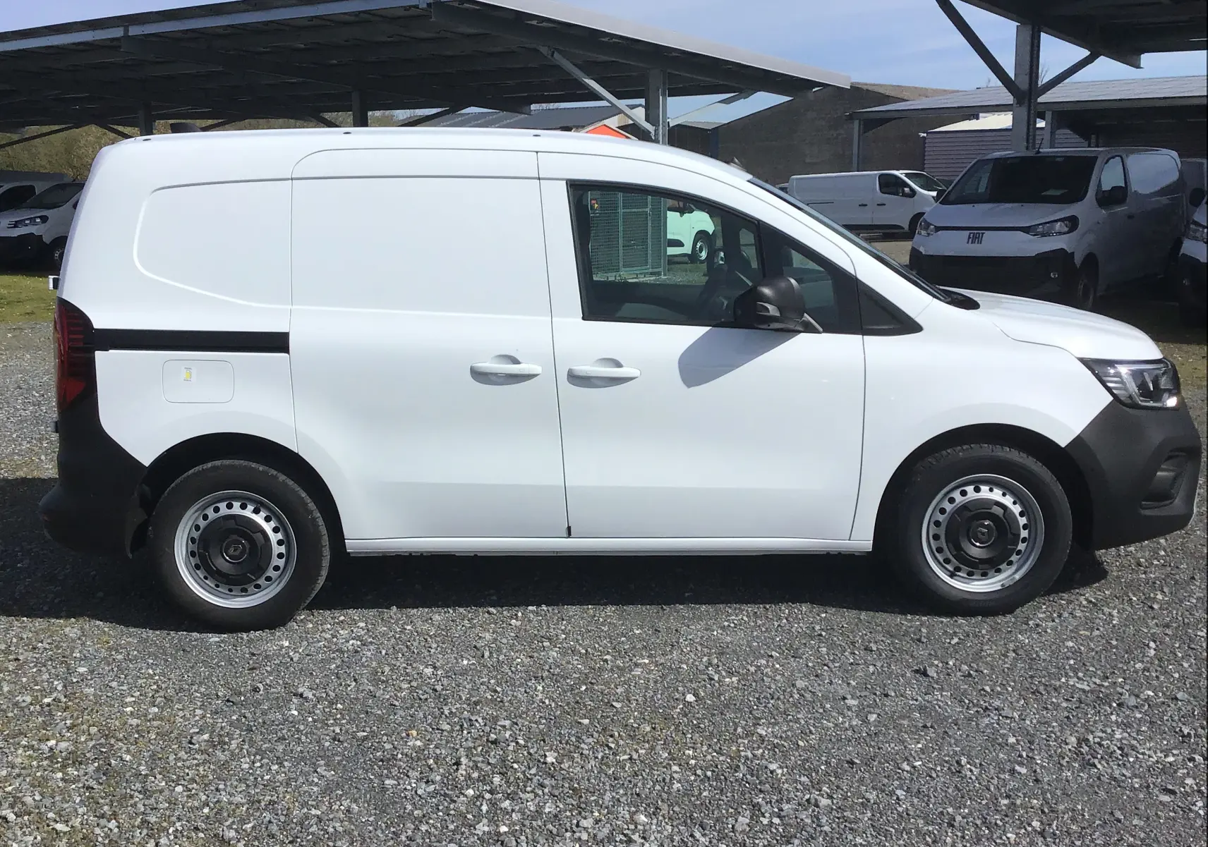 Vue de profil côté gauche d’un Renault Kangoo Van blanc 2024 avec jantes acier et carrosserie lisse sans vitres arrière.