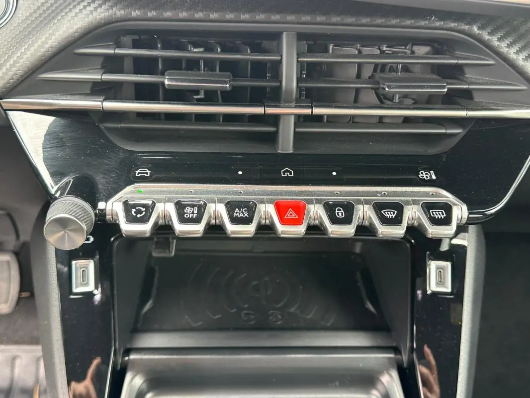 Gros plan sur la console centrale de la Peugeot 2008 Hybrid 136 e-DCS6 Allure, boutons de commande et prise USB visibles.