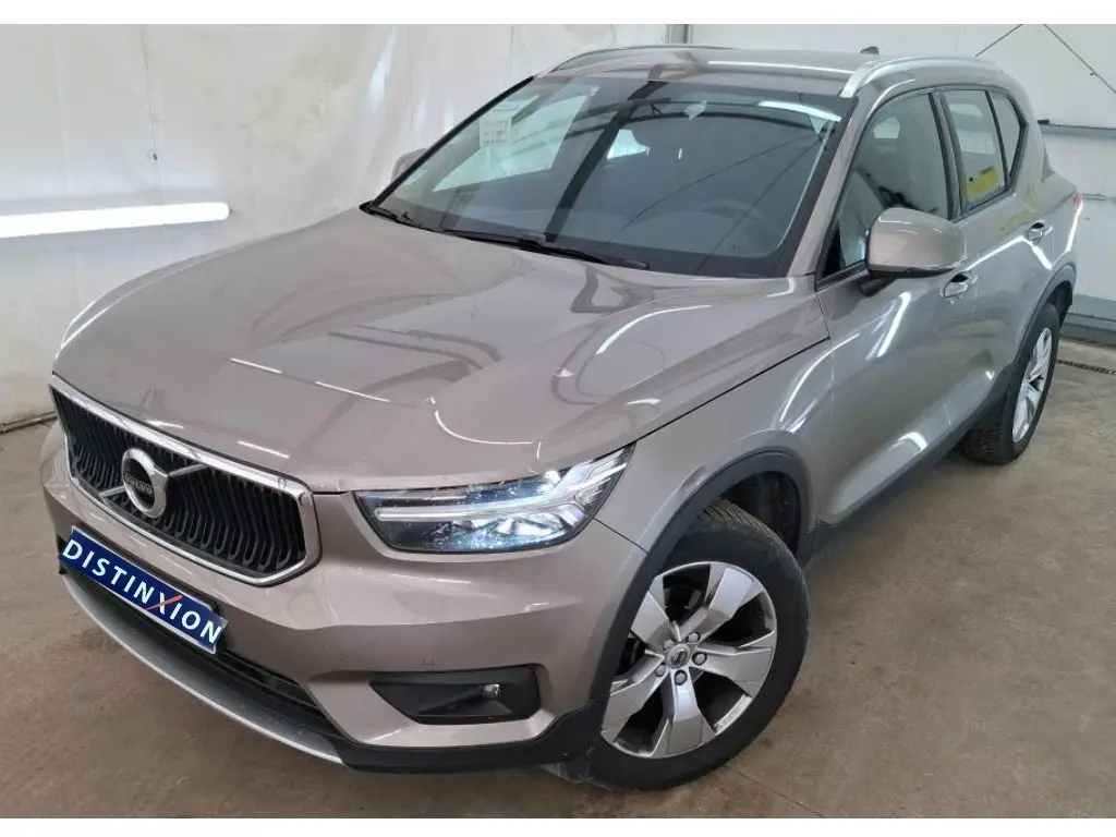 Volvo XC40 marron clair vue 3/4 avant droit, avec calandre noire et jantes alliage cinq branches.