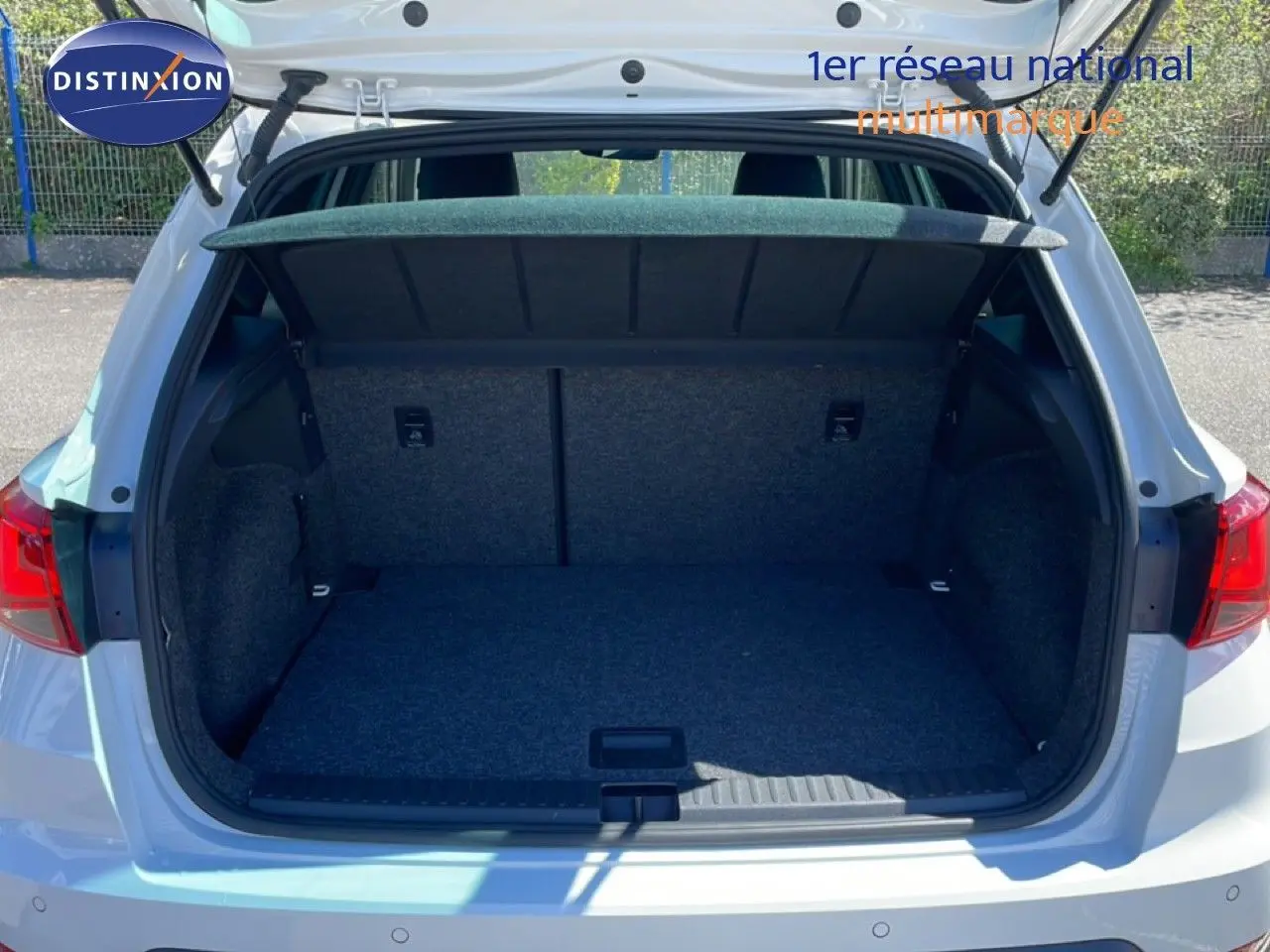 Coffre ouvert vu de l'arrière d'un SEAT Arona blanc à toit noir, montrant l'espace de chargement vide.