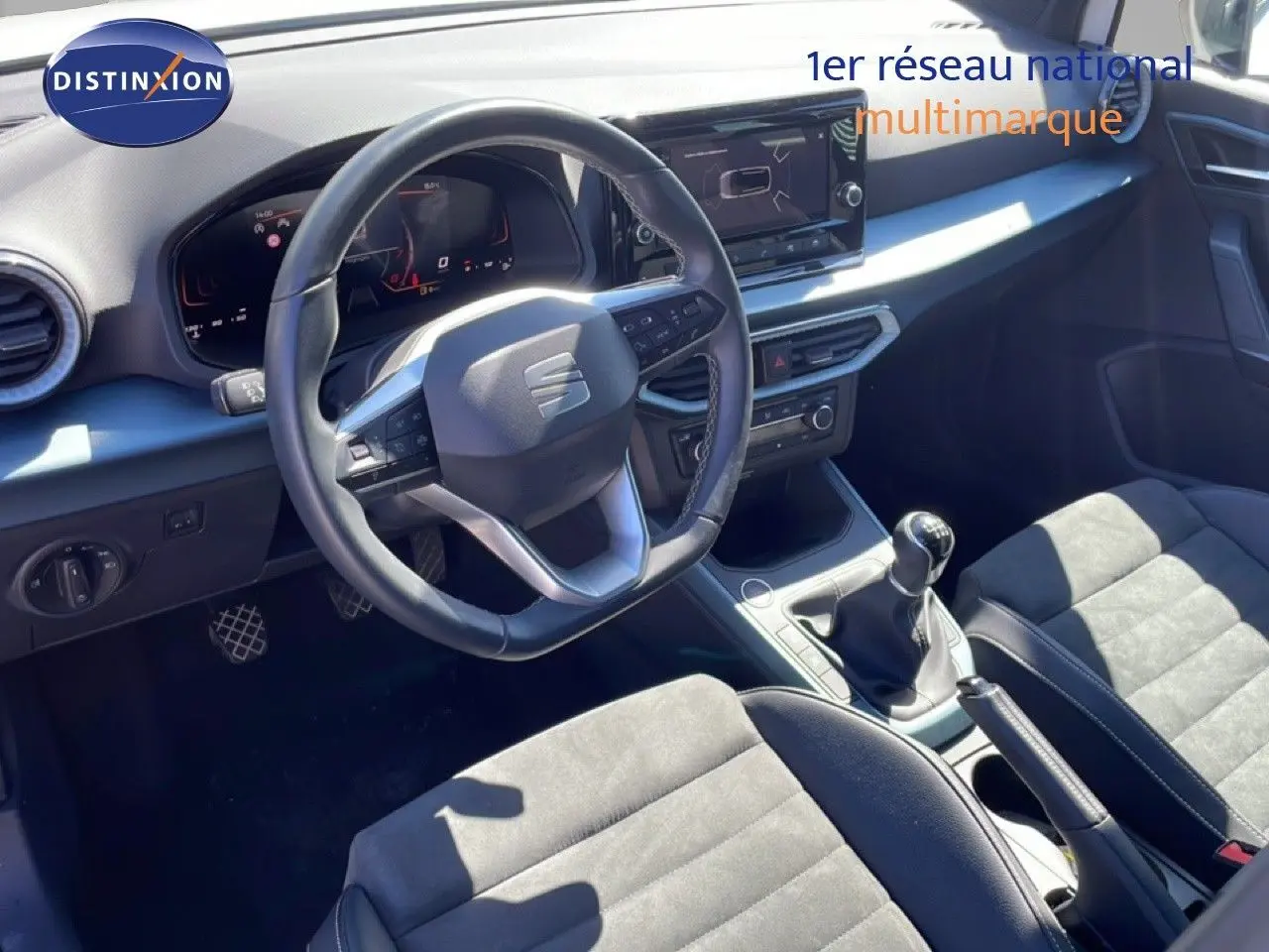 Vue intérieure avant du SEAT Arona 2025 avec volant cuir, boîte manuelle et sièges alcantara noirs.