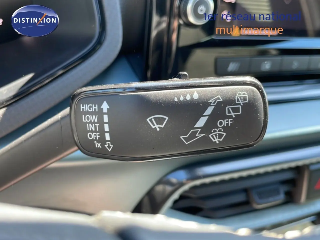 Gros plan sur la commande d’essuie-glace dans l’habitacle d’une SEAT Arona blanc toit noir, avec tableau de bord en arrière-plan.