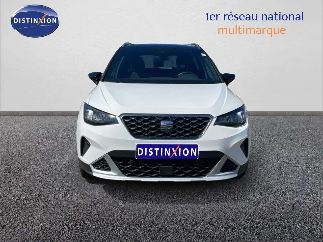 Vue avant d'un SEAT Arona blanc avec toit noir, calandre noire et phares LED, sur fond neutre.