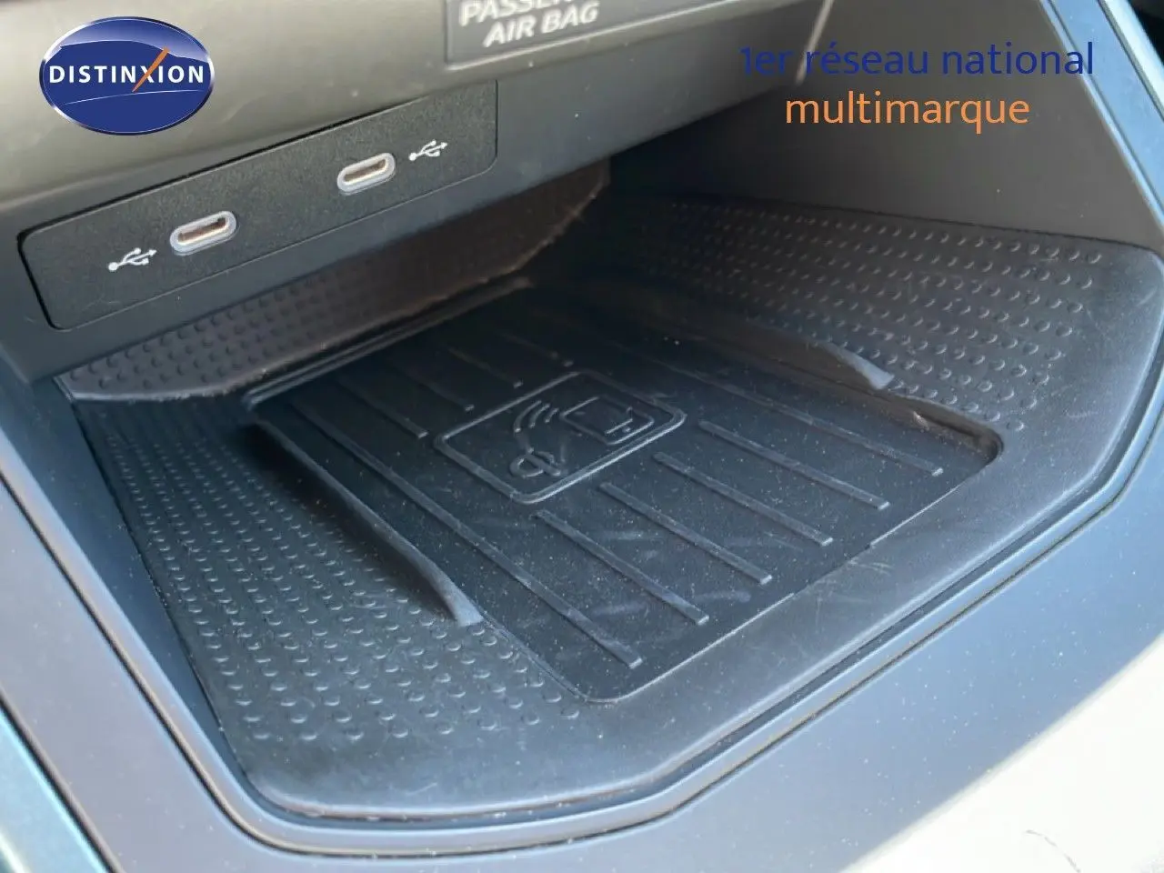 Gros plan sur le compartiment de recharge sans fil et ports USB dans l'habitacle du SEAT Arona 2025 blanc toit noir.