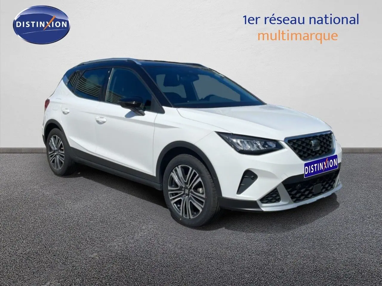 SEAT Arona 2025 blanc toit noir en 3/4 avant droit, avec jantes alliage et calandre noire distinctive.