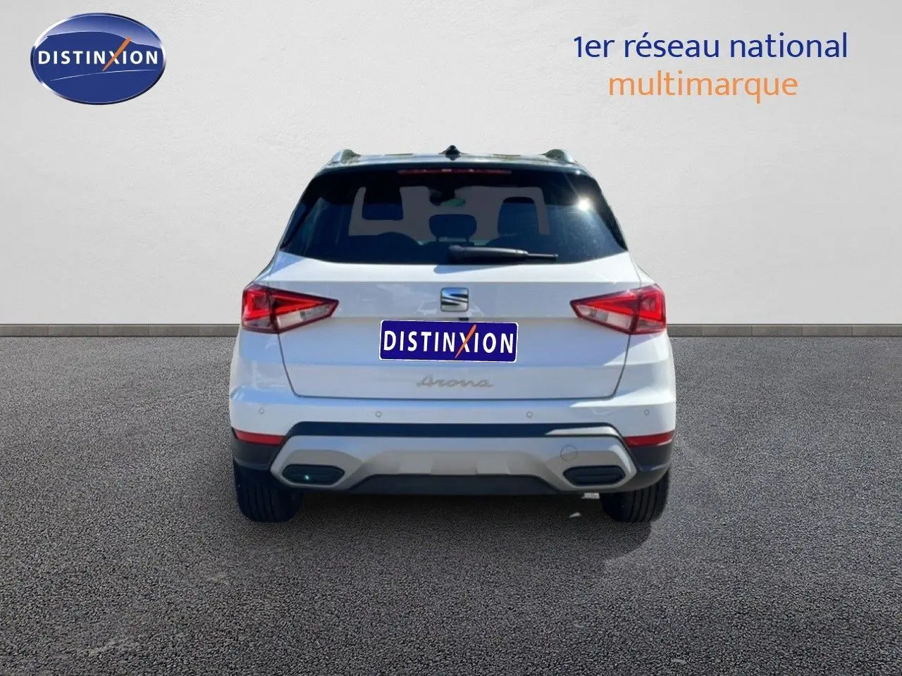 Vue arrière d'un SEAT Arona blanc avec toit noir, affichant ses feux arrière et son pare-chocs gris.