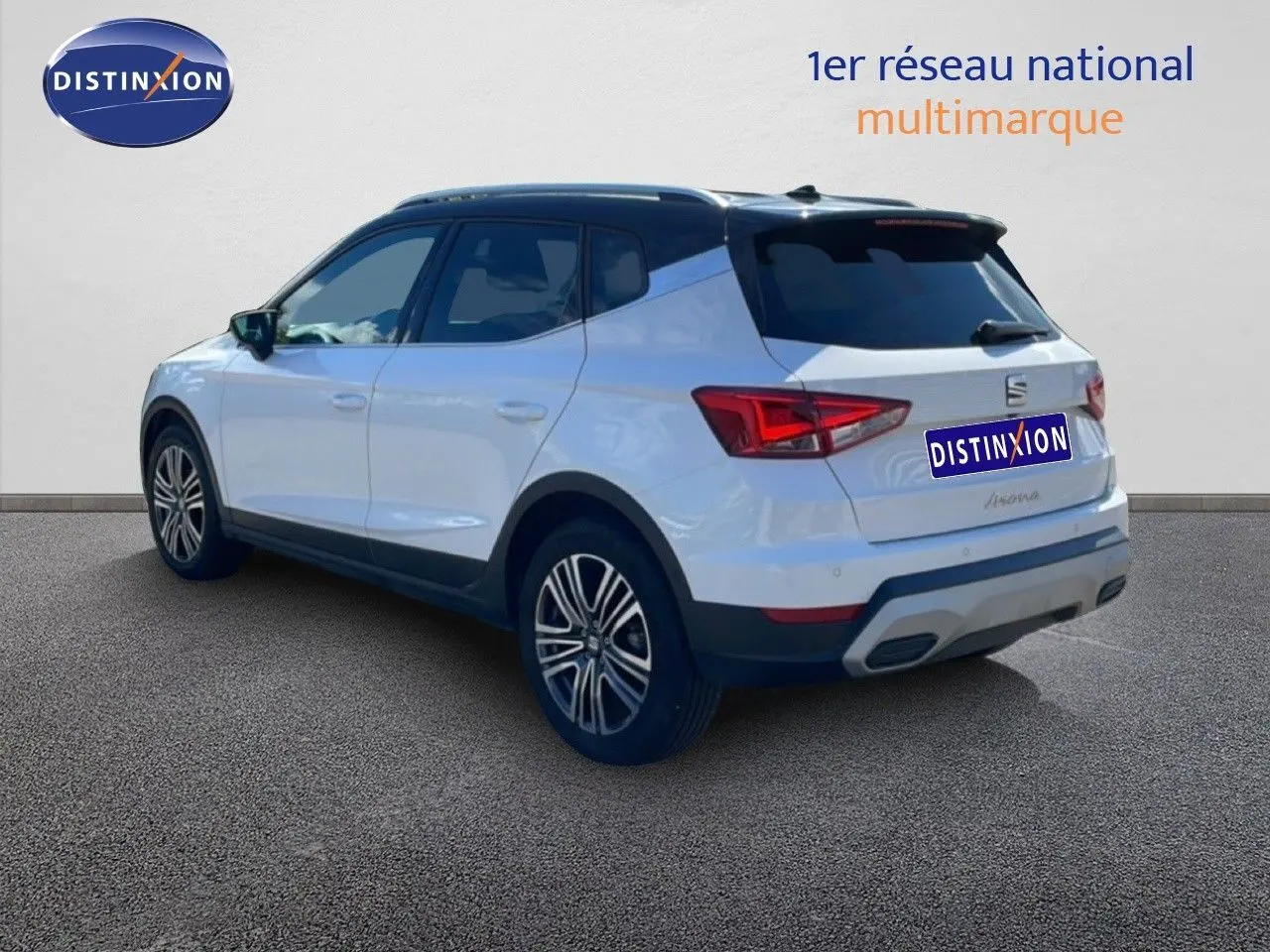 Vue 3/4 arrière droite d’un SEAT Arona blanc avec toit noir, jantes alliage et feux arrière LED.