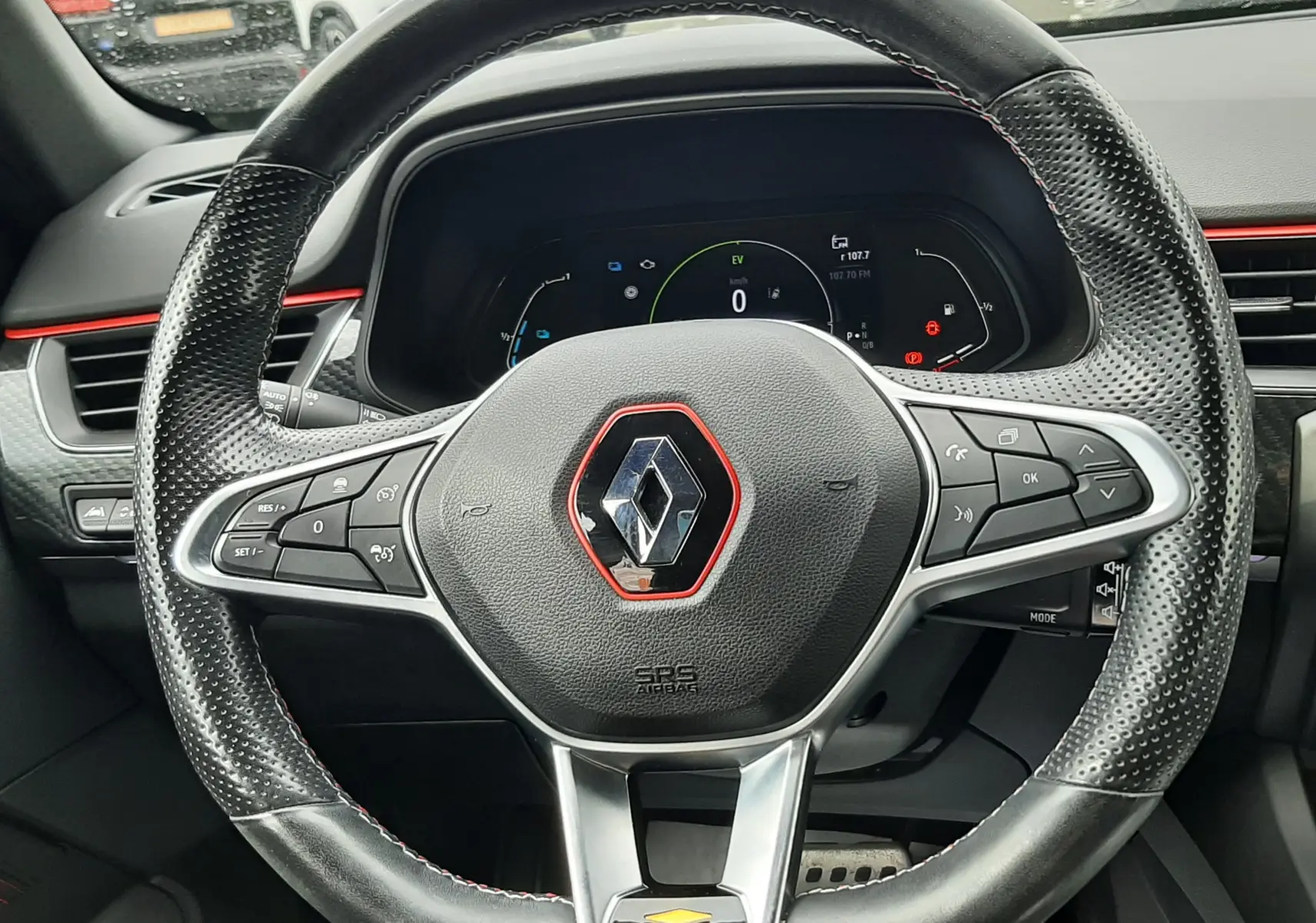 Vue rapprochée du volant cuir perforé avec logo Renault rouge du tableau de bord du Renault Arkana E-Tech 145ch.