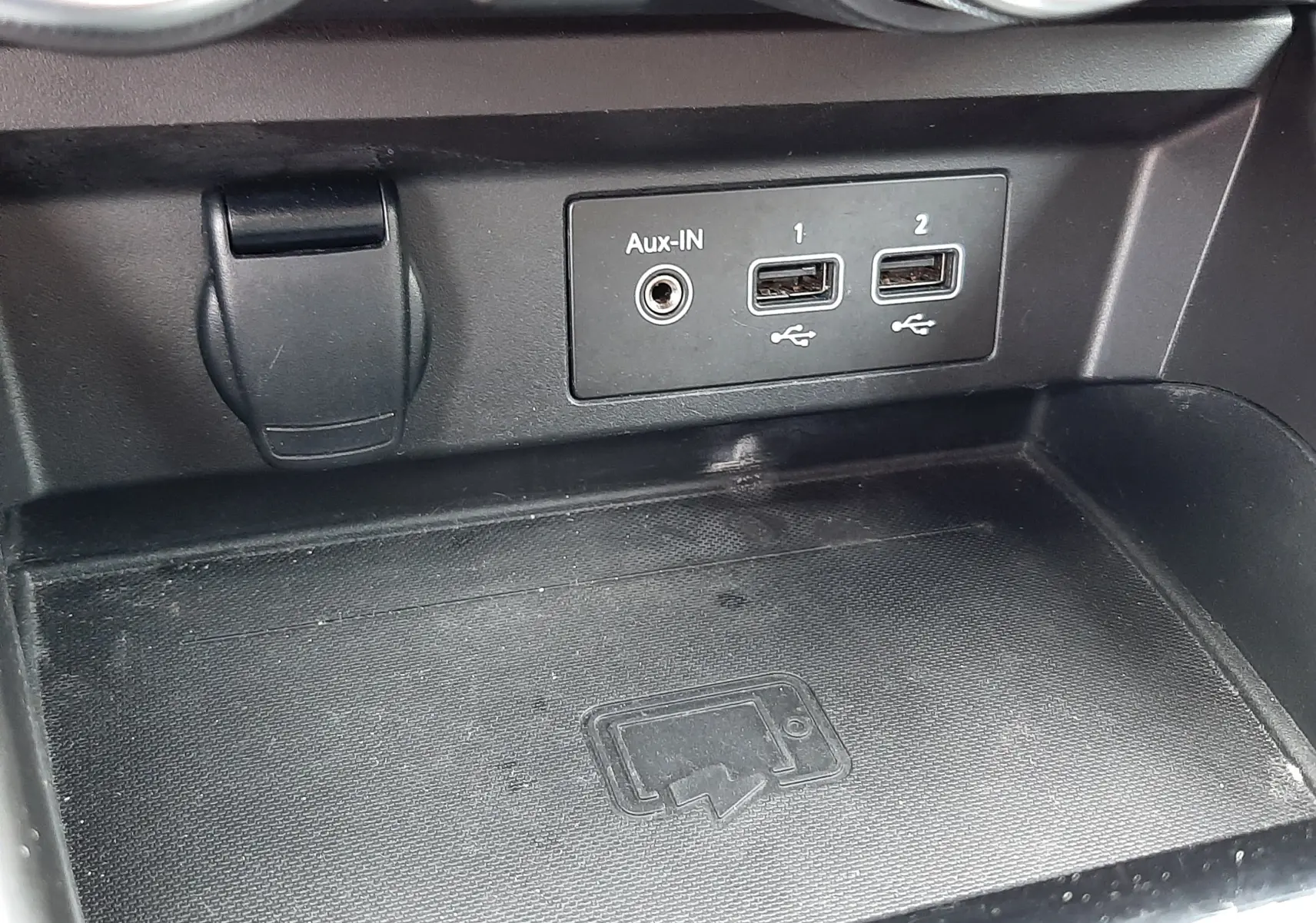 Gros plan sur la console centrale du Renault Arkana E-Tech 145ch RS-Line 2021, montrant les ports USB, entrée Aux-IN et surface de recharge sans fil.