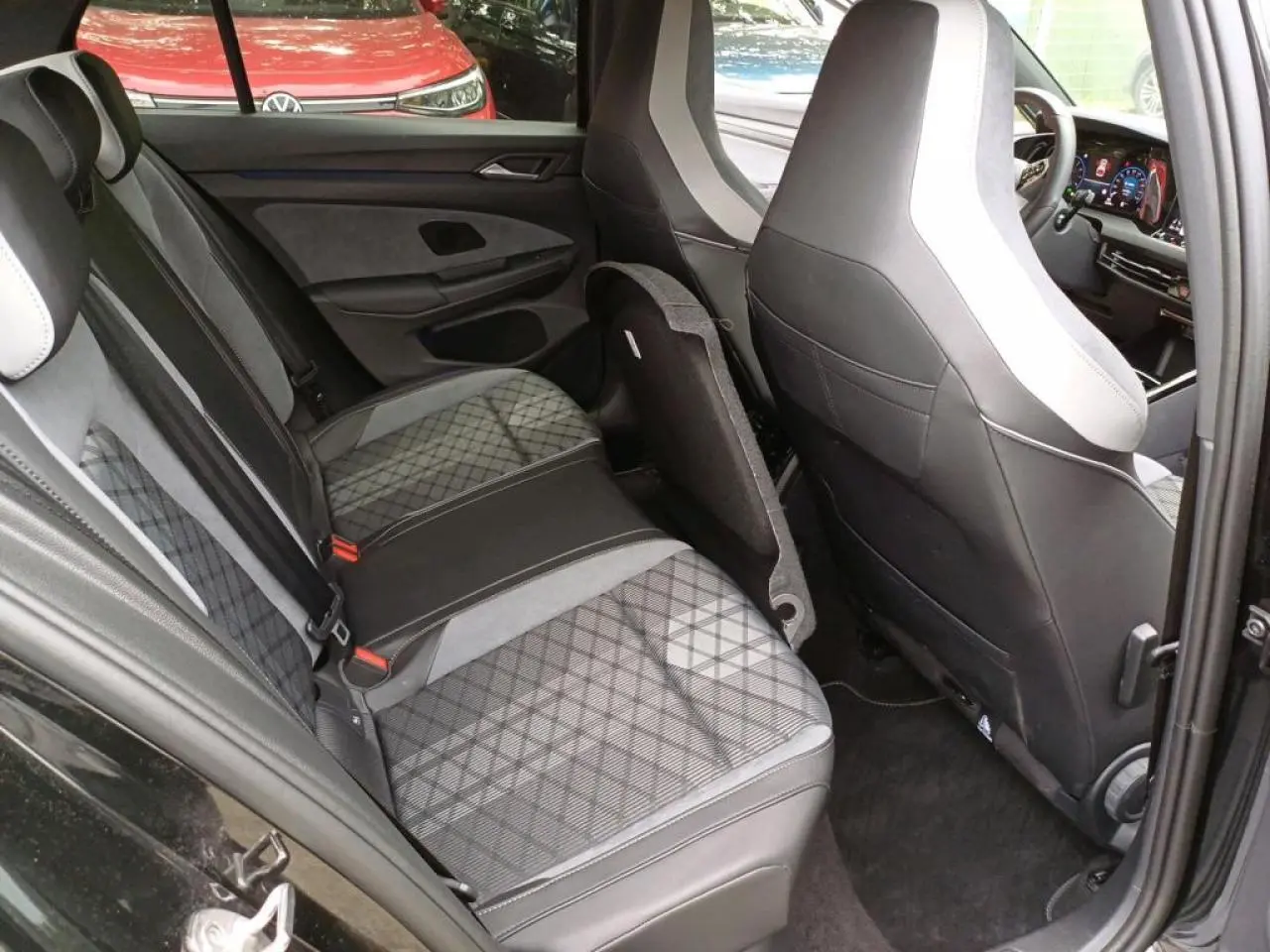 Vue intérieure côté gauche montrant la banquette arrière et les sièges avant en cuir noir et gris d'une Volkswagen Golf VIII R-Line.