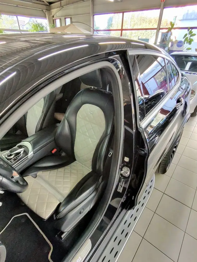Vue côté gauche intérieur d'une Mercedes GLC 350 Sportline noire de 2017, mettant en valeur le siège avant bi-ton cuir noir et beige matelassé.
