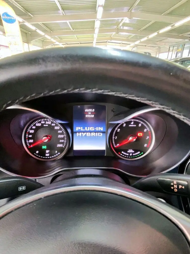 Vue intérieure du tableau de bord du Mercedes GLC 350 hybride, affichant le compteur et l'écran central "PLUG-IN HYBRID".