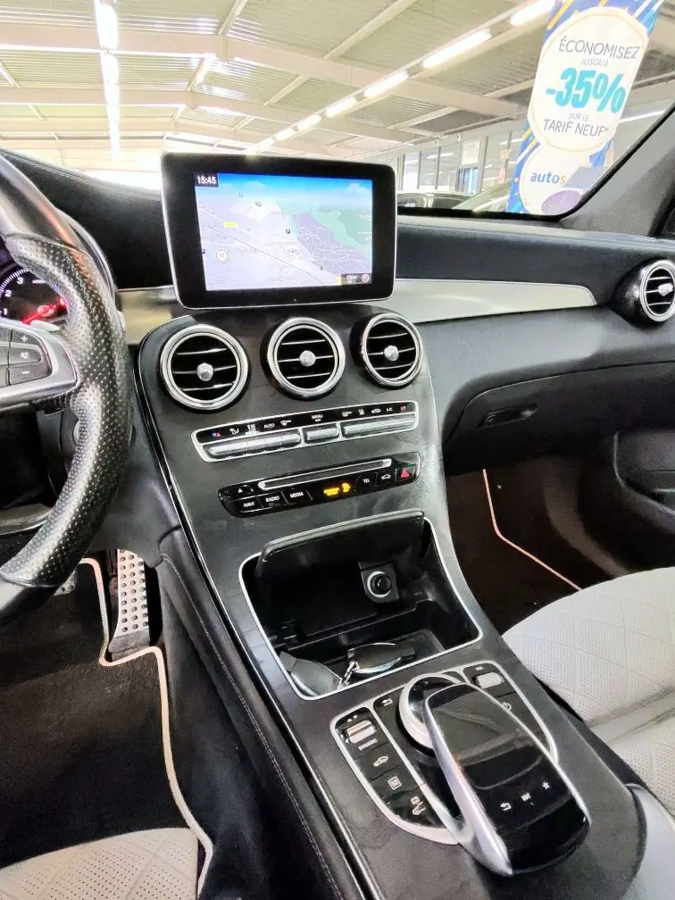 Vue intérieure de la console centrale et tableau de bord du Mercedes GLC Coupé noir avec écran GPS et commandes tactiles.