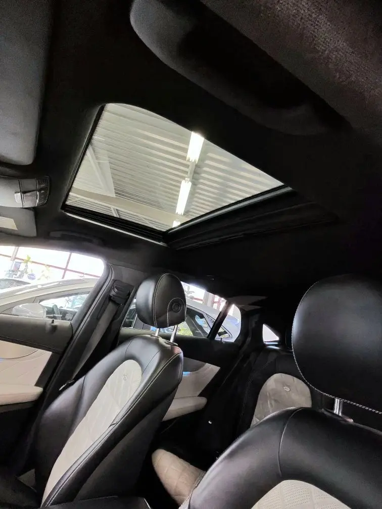 Vue intérieure du toit ouvrant panoramique et des sièges cuir bicolores noir et beige du Mercedes GLC Coupé 350 Sportline 2017.