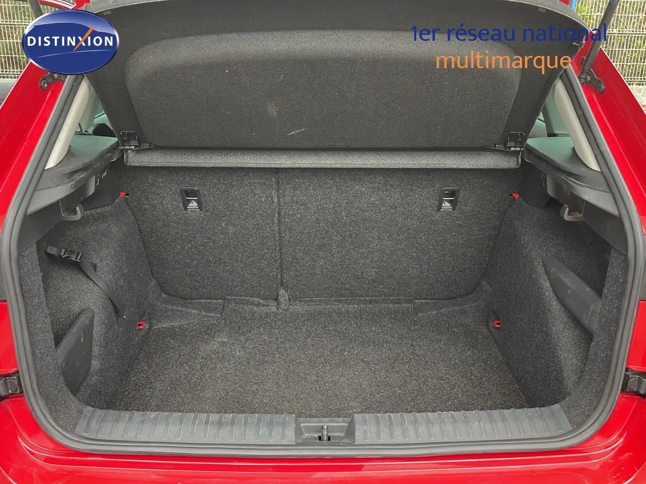 Coffre ouvert d'une Skoda Kamiq rouge Velvet Metal, vue arrière montrant l'espace de chargement vide et doublé de tissu gris.