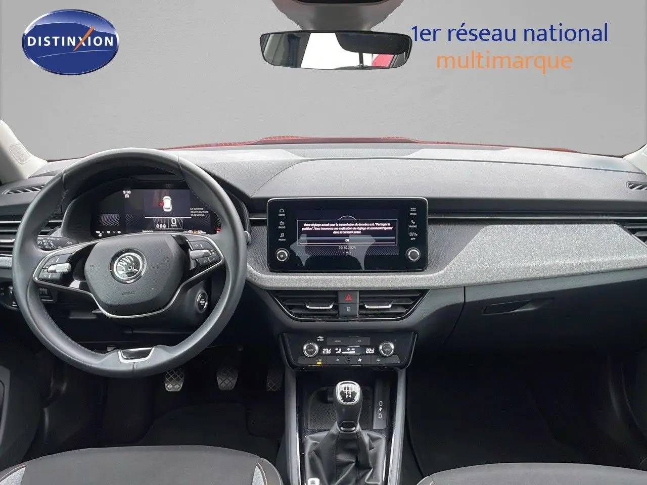 Vue intérieure frontale du tableau de bord du Skoda Kamiq rouge velvet metal avec volant multifonction et boîte manuelle.