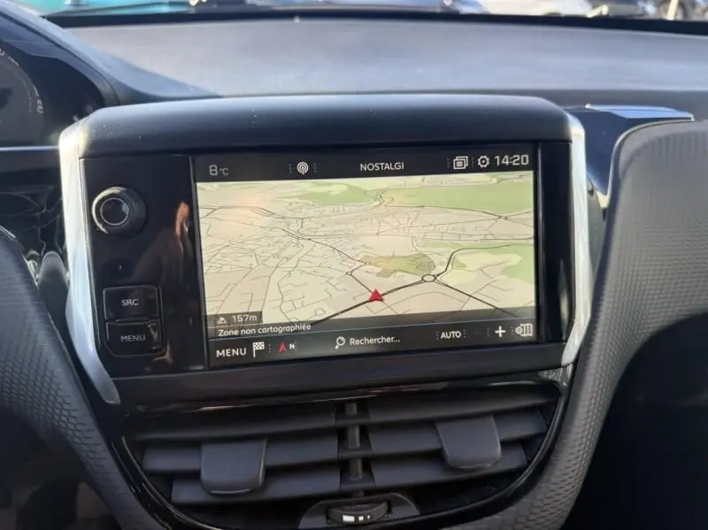 Vue rapprochée de l'écran tactile central du tableau de bord de la Peugeot 2008 blanc, affichant une carte de navigation.