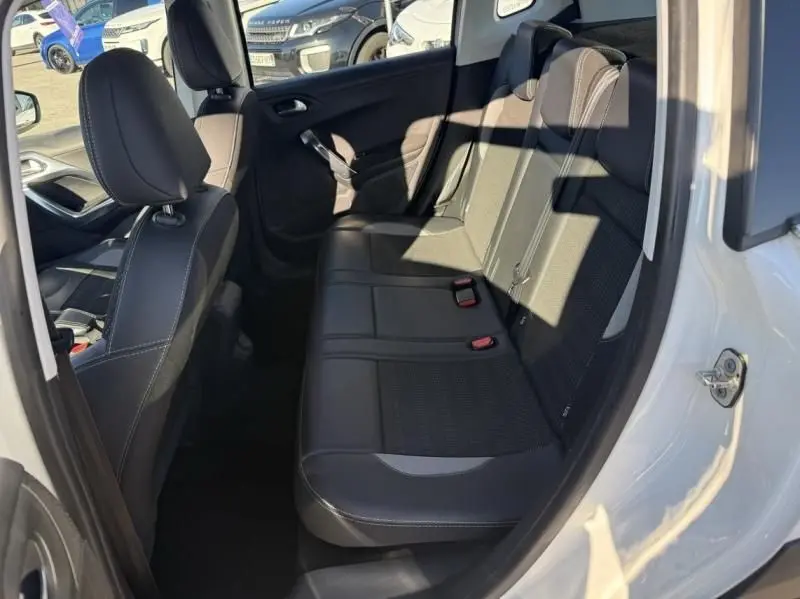 Vue intérieure côté droit arrière du Peugeot 2008 blanc de 2018, montrant les sièges arrière en tissu noir avec détails gris.