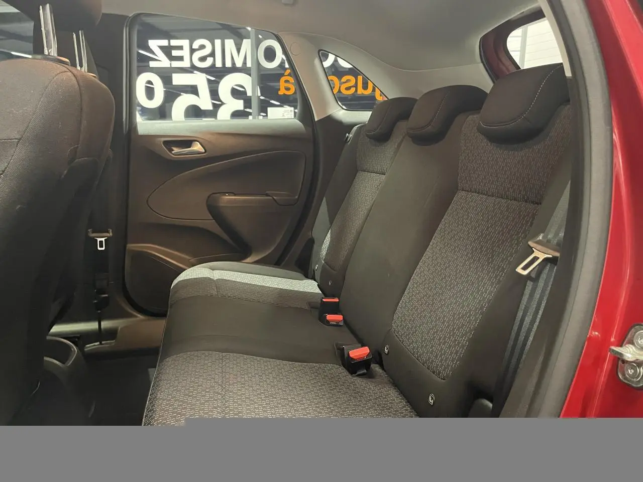 Vue intérieure côté droit sur la banquette arrière tissu gris et noir de l’Opel Crossland rouge clair 2022.