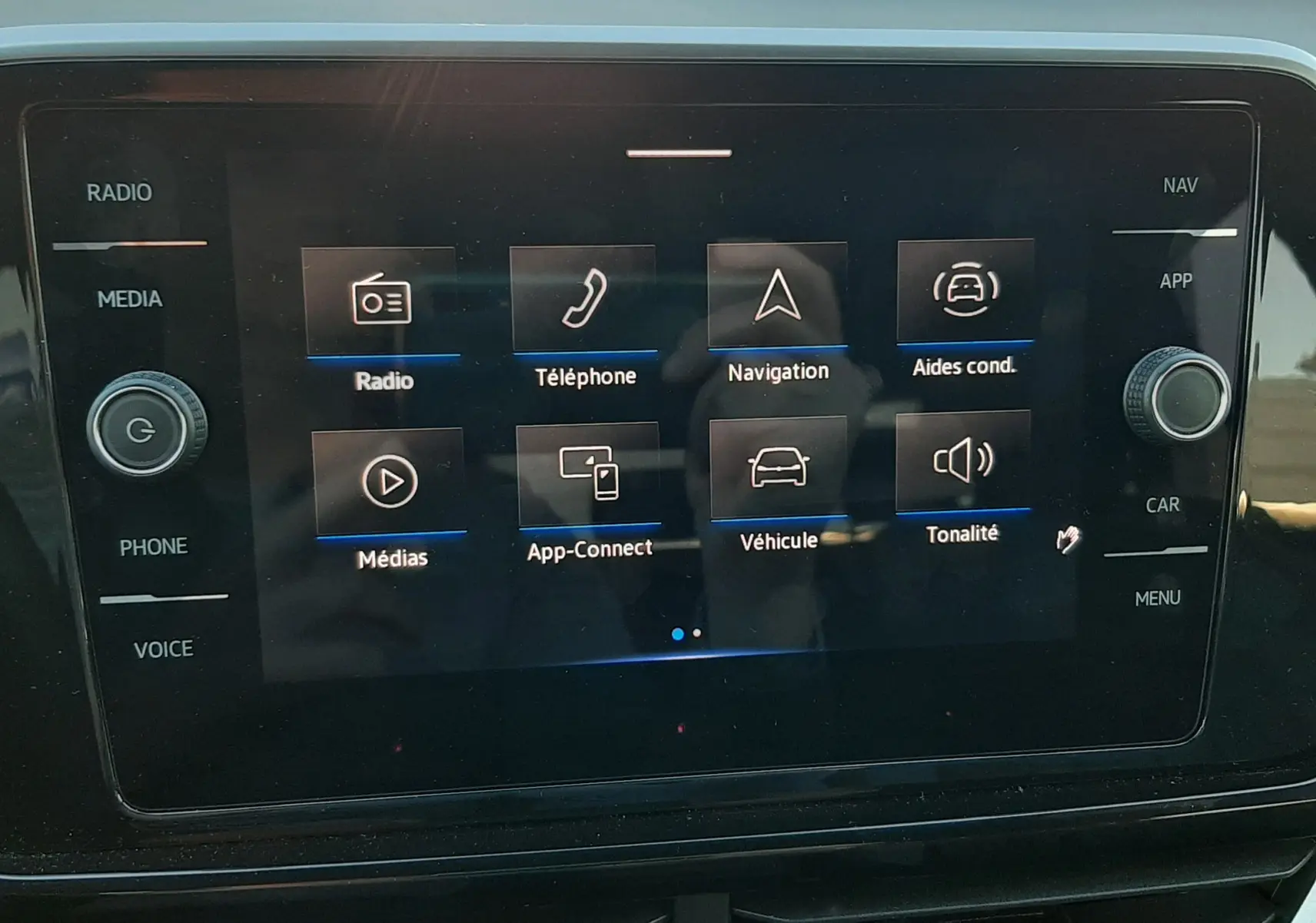 Écran tactile central du Volkswagen T-Roc 2024 affichant les options radio, téléphone, navigation et aides à la conduite.
