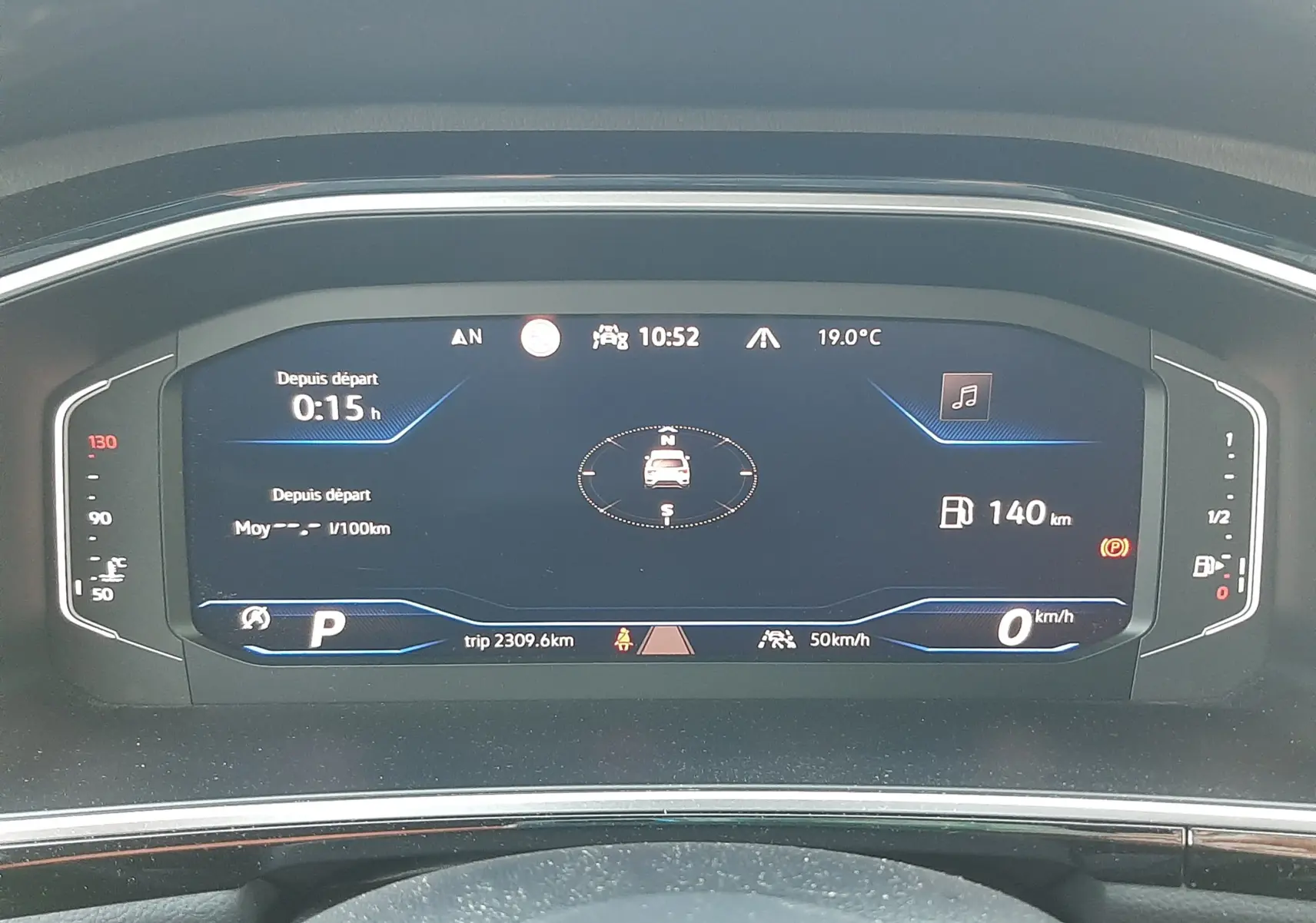 Vue rapprochée du tableau de bord numérique du Volkswagen T-Roc 2.0 TDI 150CH R-LINE 2024 affichant la vitesse, la boussole et l'autonomie.