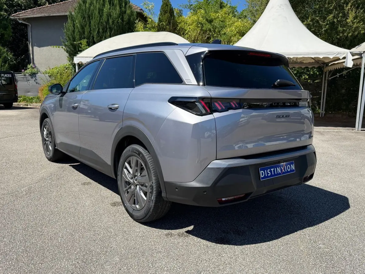 Vue 3/4 arrière droite d’un Peugeot 5008 gris clair avec feux arrière LED et vitres teintées.