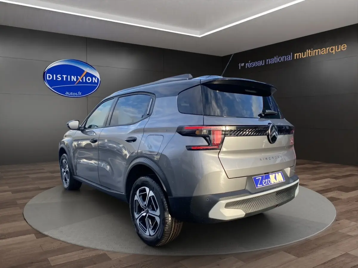 Vue 3/4 arrière droite d’un Citroën C3 Aircross hybride gris foncé avec feux arrière LED et jantes distinctives.