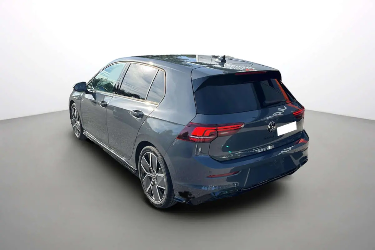 Vue 3/4 arrière gauche d'une Volkswagen Golf gris dauphin avec jantes alu 18 pouces et vitres surteintées.