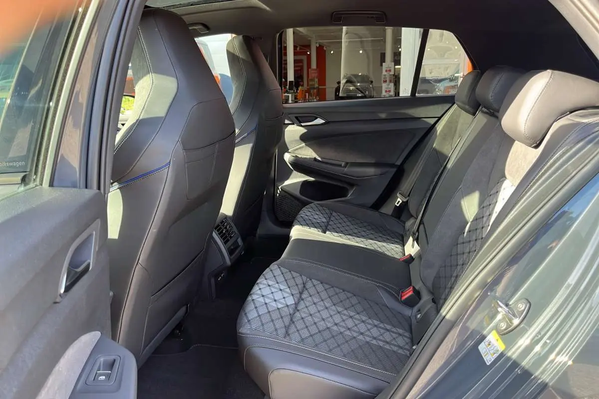 Vue intérieure côté gauche de la banquette arrière en tissu et cuir gris avec surpiqûres sur une Volkswagen Golf gris dauphin.