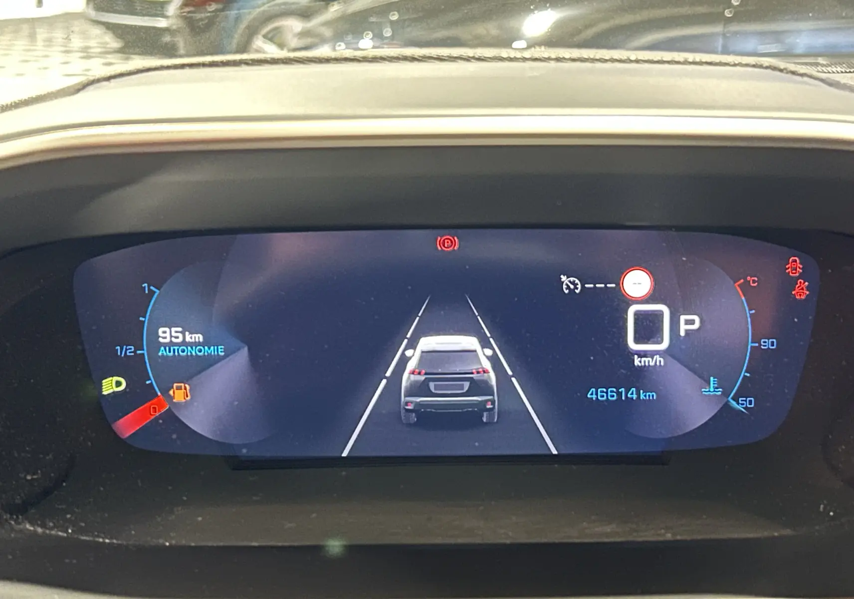 Affichage numérique du tableau de bord Peugeot 2008 Puretech 130, montrant l'autonomie, la vitesse à 0 km/h et l'icône de frein à main.