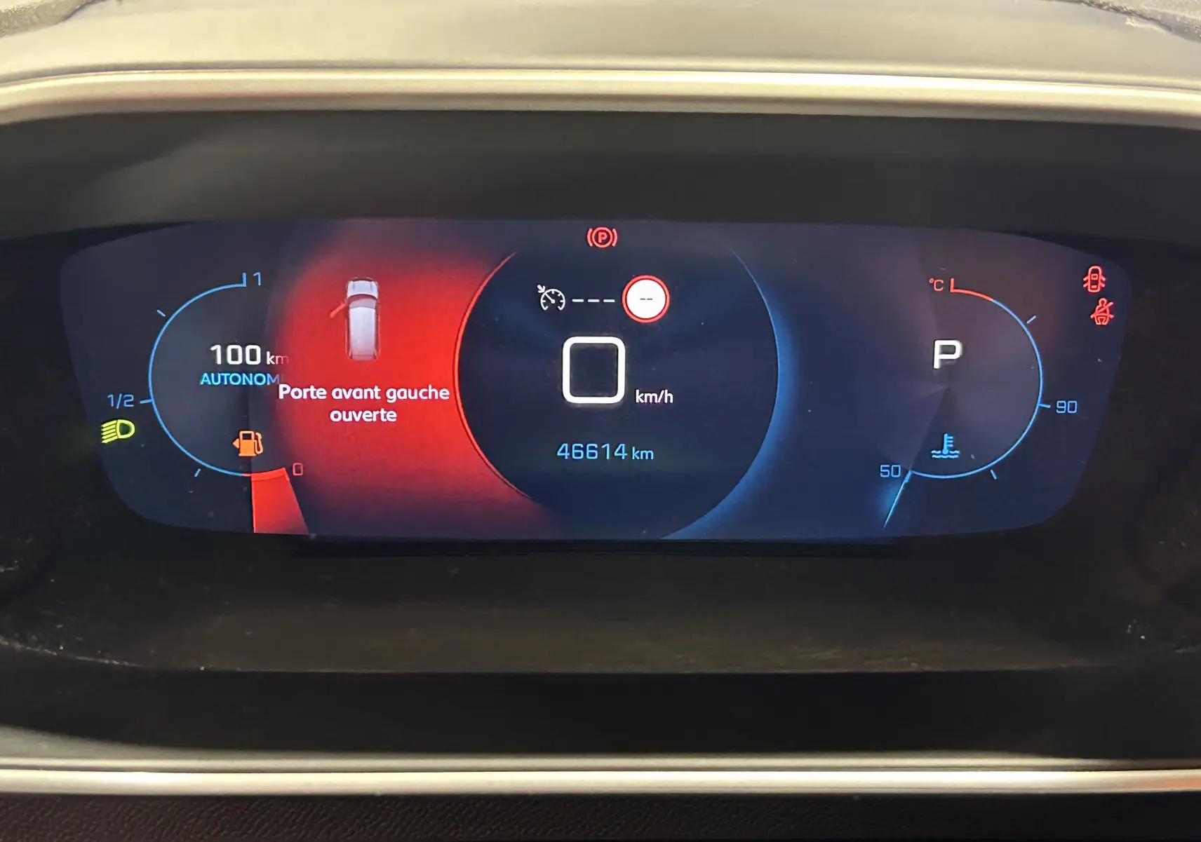 Tableau de bord numérique du Peugeot 2008 affichant porte avant gauche ouverte et vitesse à 0 km/h.