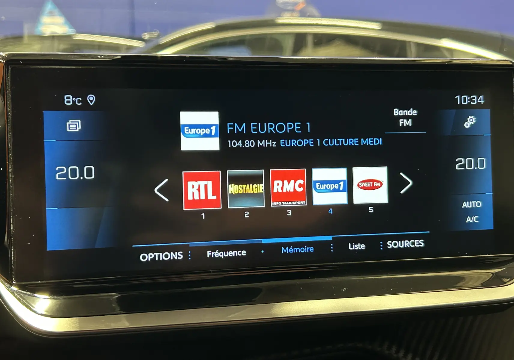 Écran tactile du système multimédia de la Peugeot 2008 gris Artense affichant les stations radio FM avec température à 20°C.