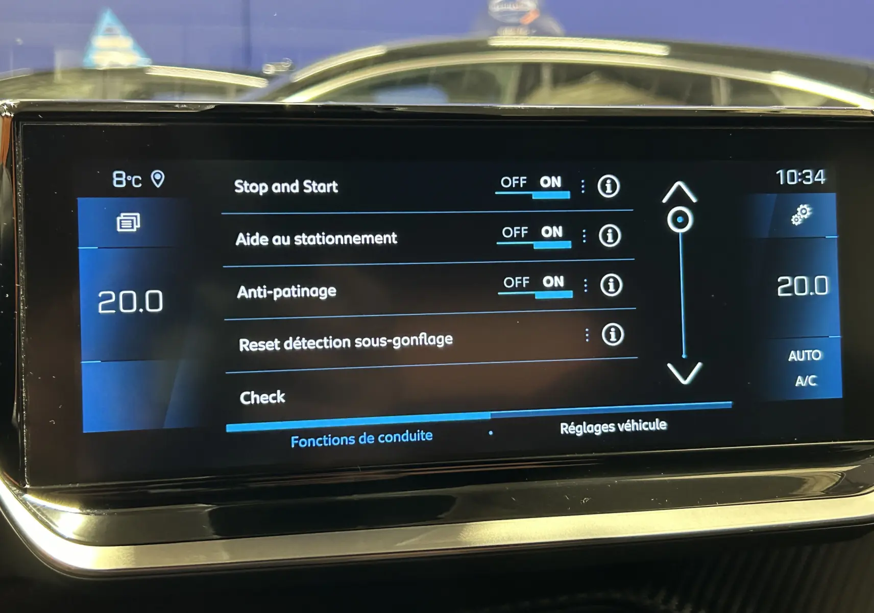 Écran tactile intérieur du Peugeot 2008 gris Artense affichant les réglages d’aide à la conduite et la température à 20°C.