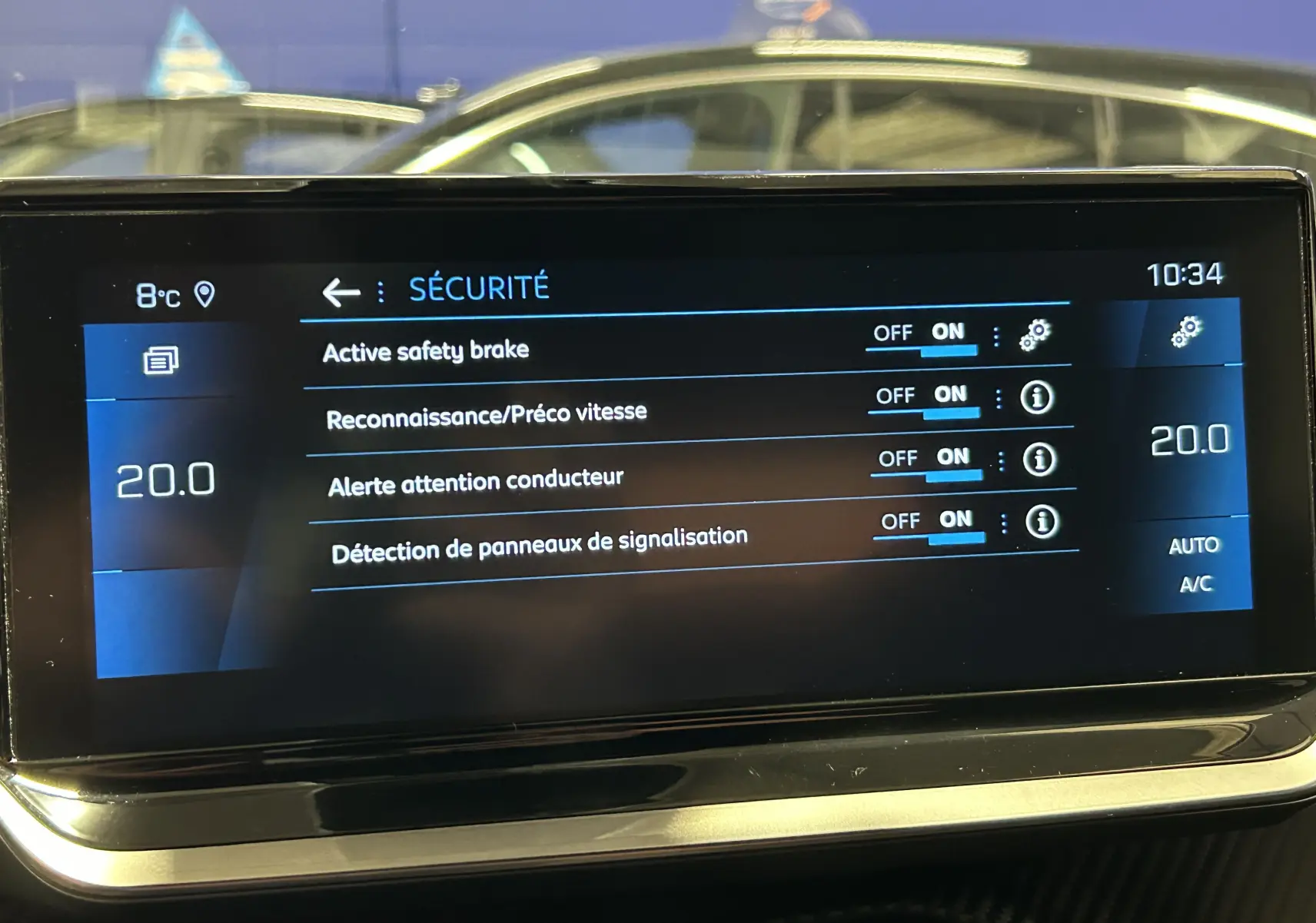 Écran tactile intérieur du Peugeot 2008 gris Artense affichant les réglages de sécurité et la température à 20°C.