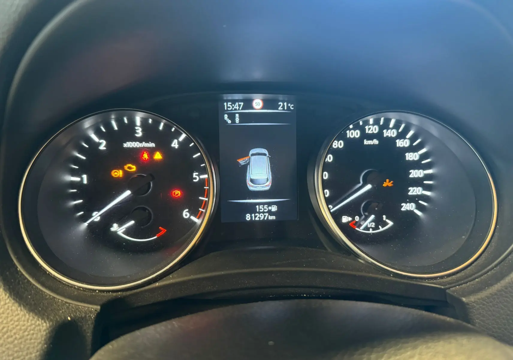 Tableau de bord du Nissan Qashqai noir 2017, affichage central avec porte ouverte et compteurs analogiques.