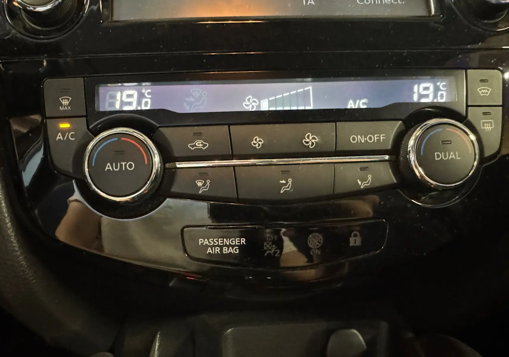 Gros plan sur la console de climatisation automatique bi-zone du Nissan Qashqai noir, affichant 19°C.