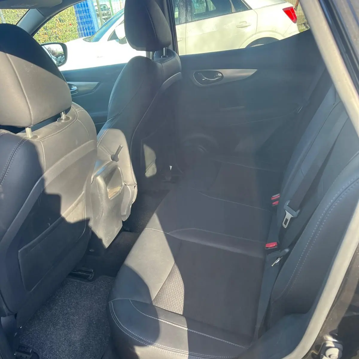 Vue arrière d'un Nissan Qashqai noir 2017 dans un garage avec feux arrière et logo visibles.