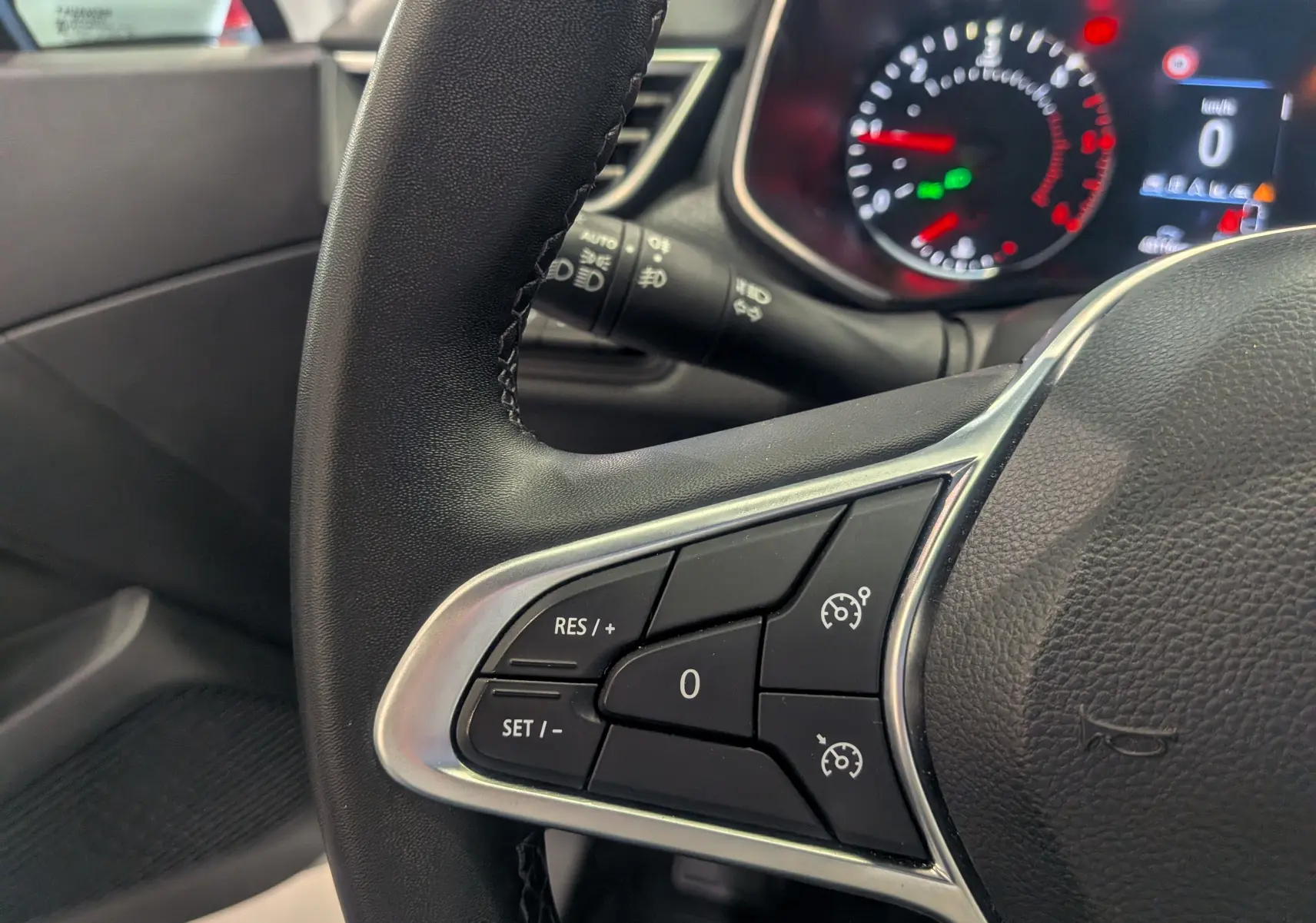 Gros plan sur le volant côté gauche de la Renault Clio V Business 2020, avec commandes de régulateur de vitesse visibles.
