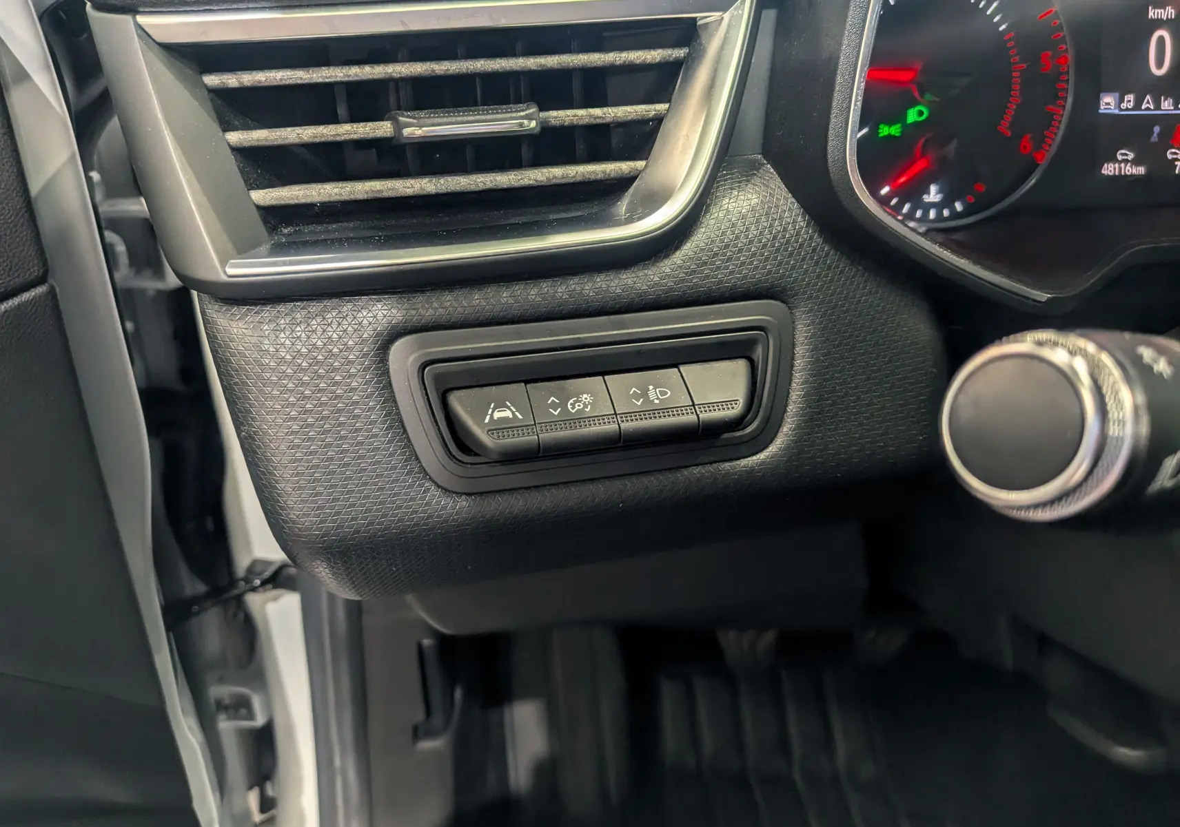 Vue intérieure côté gauche du tableau de bord de la Renault Clio V blanche, avec commandes d'assistance et ventilation visibles.