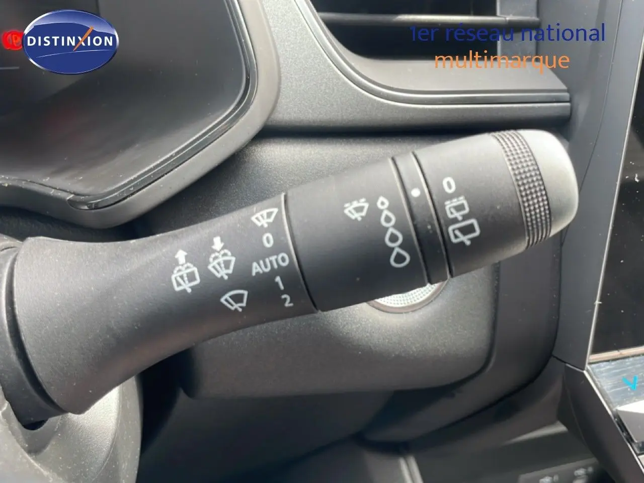 Gros plan sur la commande d’essuie-glace du Renault Captur 2025, intérieur gris noir, détails des pictogrammes visibles.