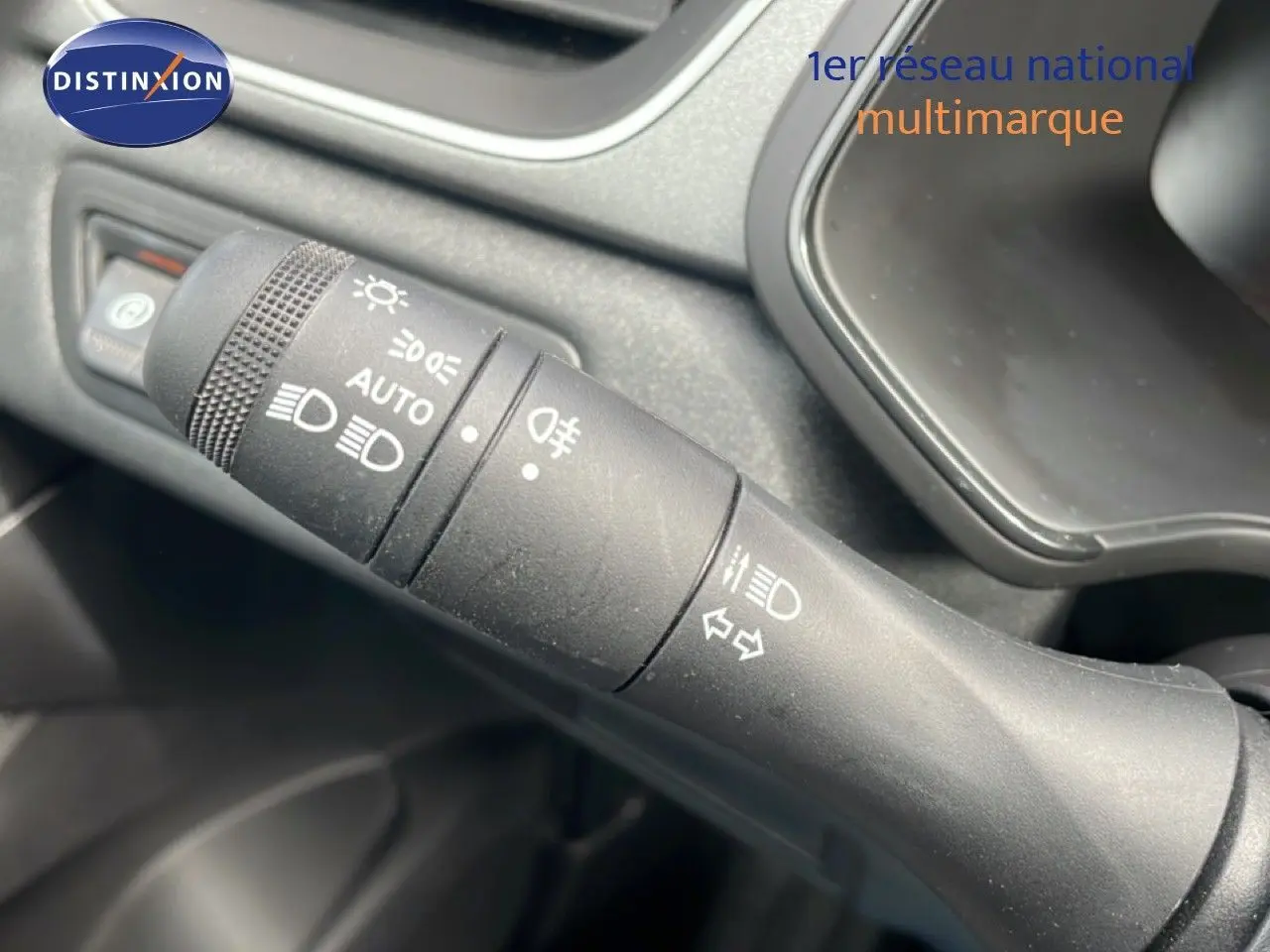 Gros plan sur la commande des phares et clignotants du Renault Captur gris Cassiopée métal avec toit noir.